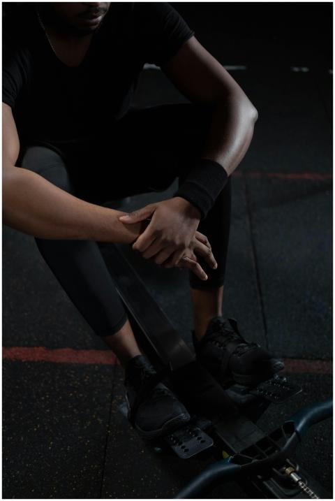 A man in sportswear resting on a rowing machine in