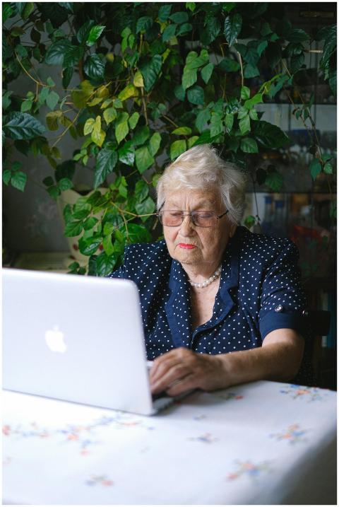 Senior woman working on a laptop surrounded by ind