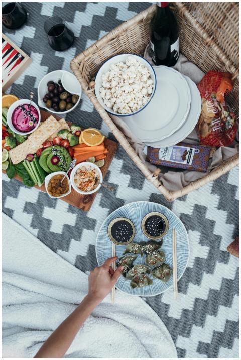 A colorful picnic setup featuring dumplings, popco