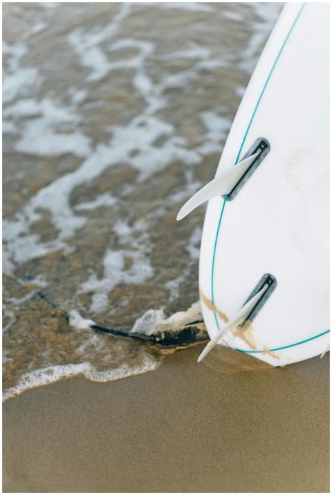A detailed view of a surfboard resting on the wet