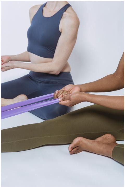 Two women in activewear exercising with a resistan