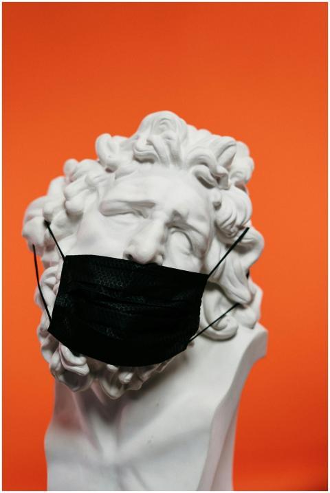 A marble bust adorned with a black face mask set a