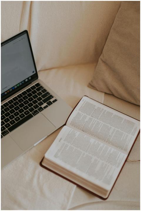 A cozy home setting with an open Bible and laptop