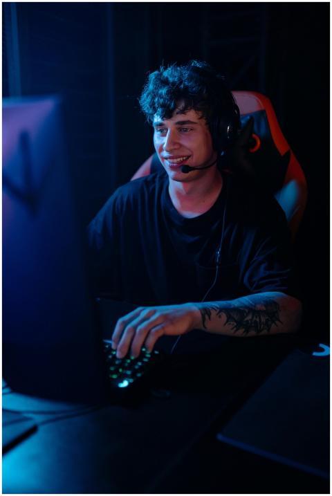 Energetic young man engaged in e-sports gaming wit