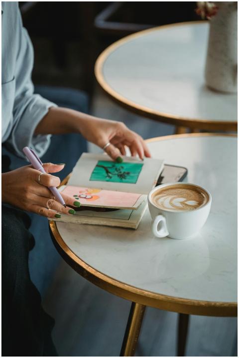 Candid moment of a woman writing in a notebook whi