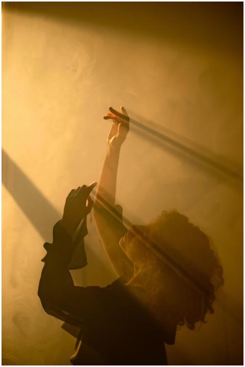 A woman in silhouette dances gracefully, enveloped