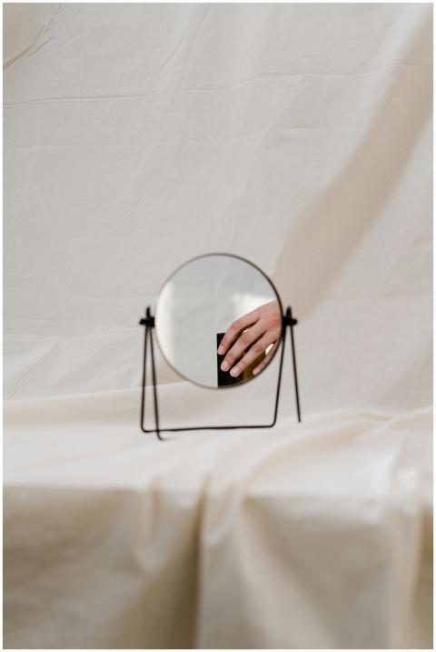 Artistic shot of a hand reflected in a round mirro