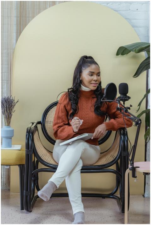 A young woman sits in a stylish home studio, recor