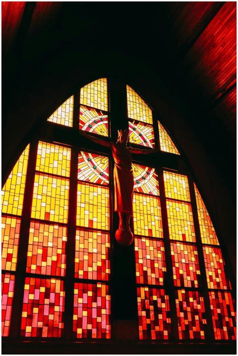 Bright stained glass window with Jesus crucifix in
