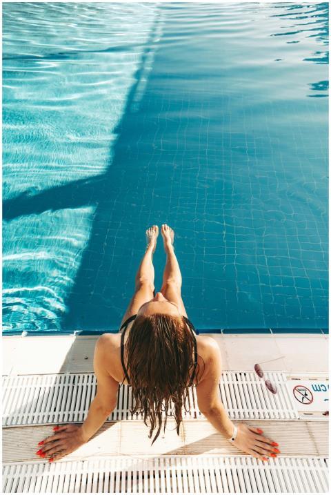 Woman in swimsuit relaxing at poolside, enjoying t