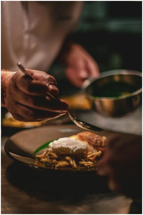 Chef artistically adds sauce to a gourmet dish in