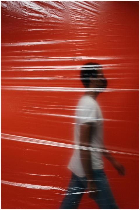 Silhouette of a man walking behind a translucent p