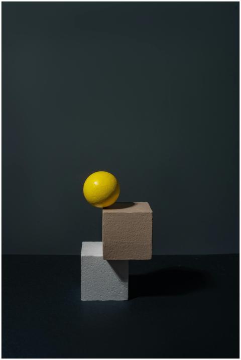 Artistic composition of a yellow sphere on geometr