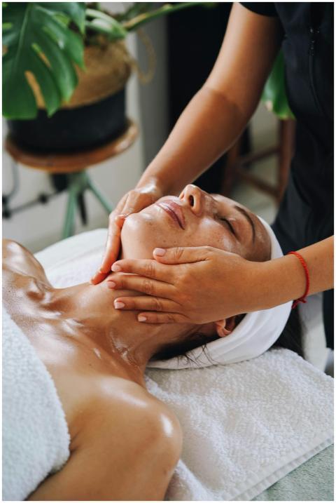 A woman enjoys a calming face massage at a spa, pr