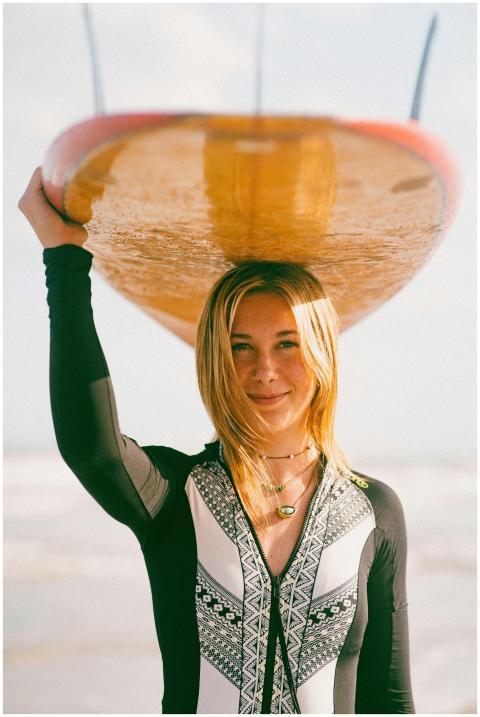 A young female surfer enjoys a sunny day at the be