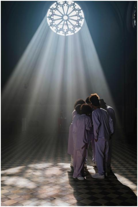 Choir group standing under dramatic light beams in