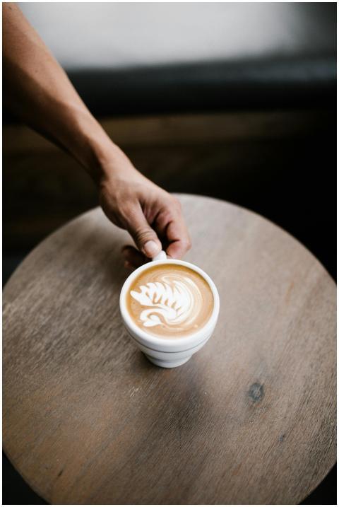 Close-up of a latte with intricate foam art on a w