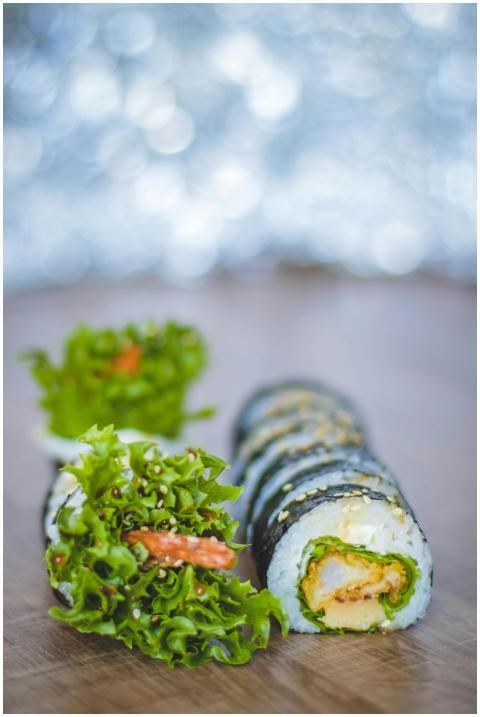 Appetizing sushi roll with seaweed and lettuce on