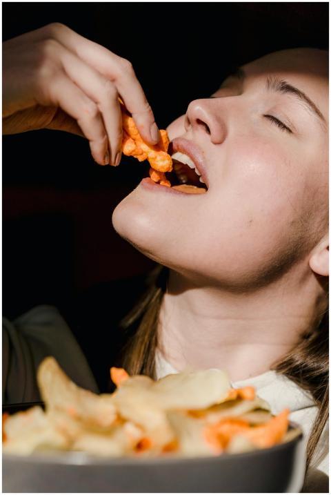 Close-up of a woman savoring delicious crunchy sna