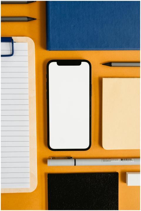Flat lay of office stationery items with a blank s