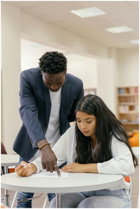 A man tutor guides a woman student during a study