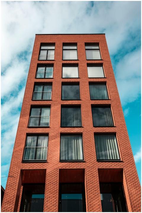 Red-brick modern building against a vibrant blue s