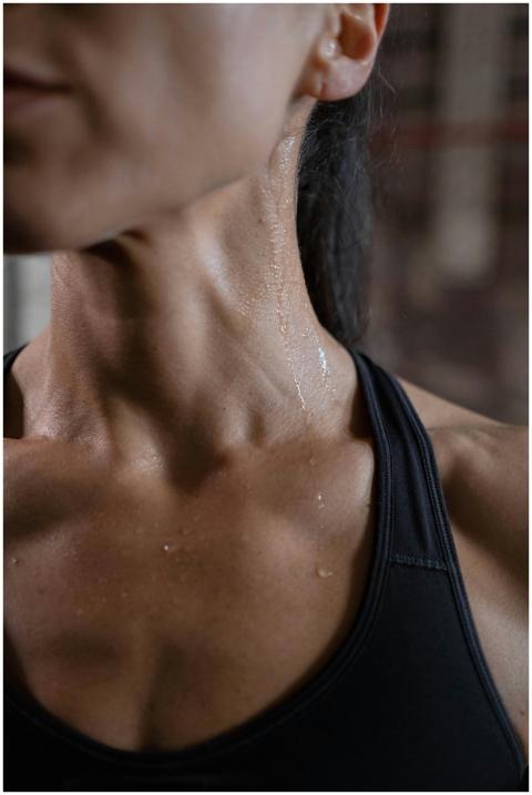 Close-up of a fit woman in activewear glistening w