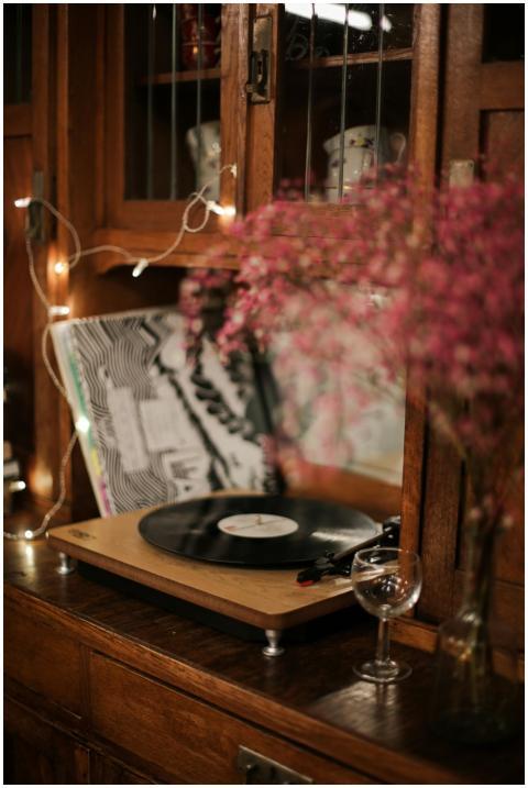 A vinyl record player on a wooden cabinet with flo