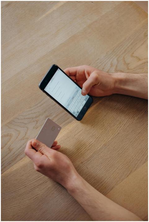 A person holds a smartphone and credit card for on