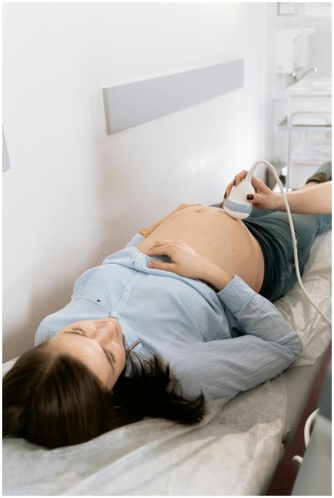 Pregnant woman receiving ultrasound in medical cli