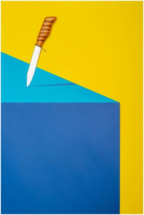 A knife on vibrant yellow, blue, and teal geometri