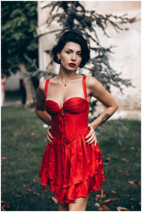 Portrait of a stylish woman in a red dress standin