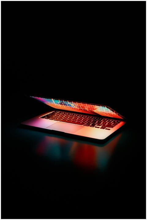 Laptop partially opened, emitting vibrant multicol