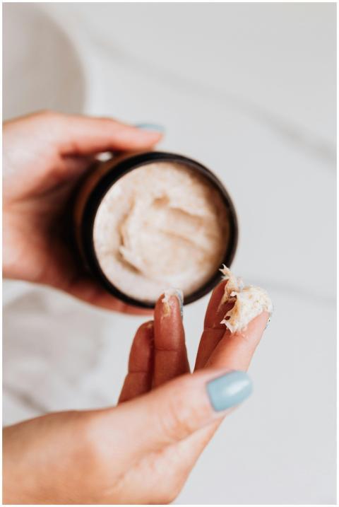 Hands applying skincare cream from a jar, perfect