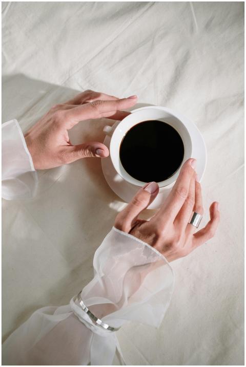 Graceful hands holding a black coffee in a white c