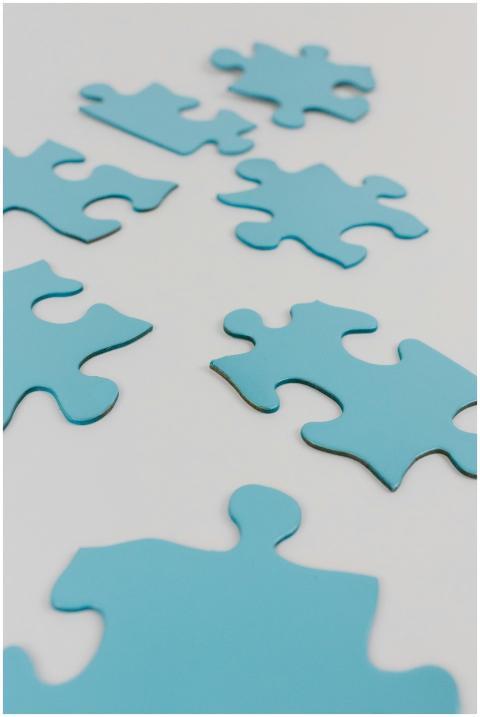 Close-up of blue puzzle pieces on a white surface,