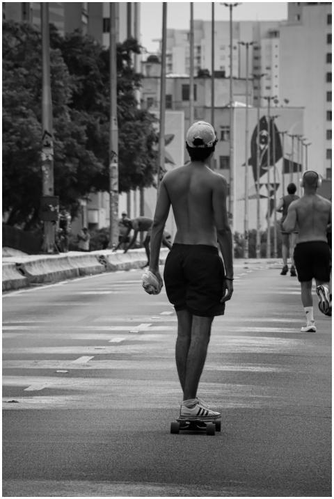 A black and white shot of a man skateboarding in a