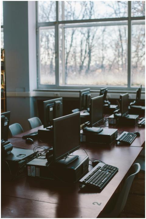 Spacious computer lab with rows of monitors and ke