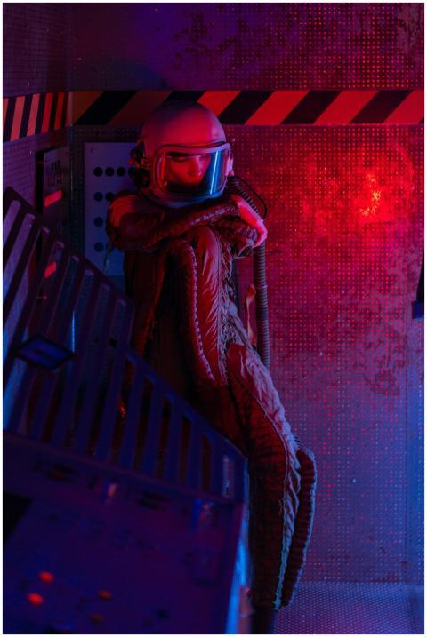 A spacewoman in a spacesuit navigates a sci-fi spa