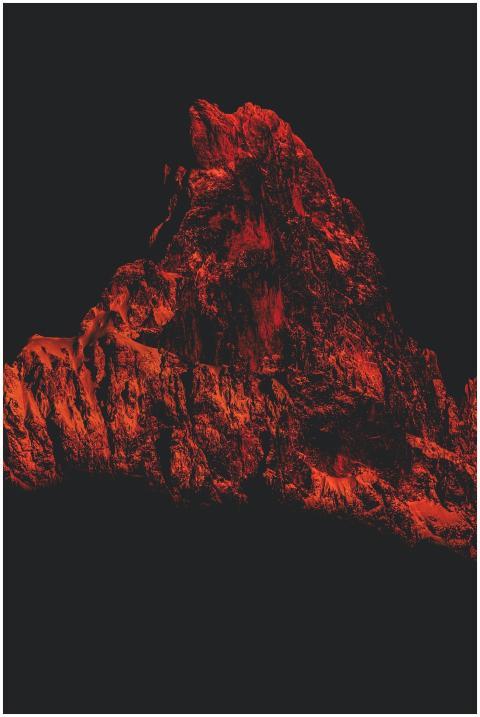 Striking silhouette of a red-illuminated mountain