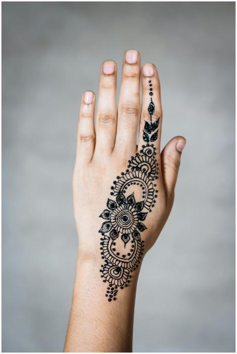 Intricate henna tattoo design on a person's hand,