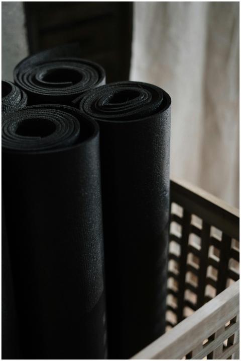 Close-up view of black yoga mats rolled and stacke