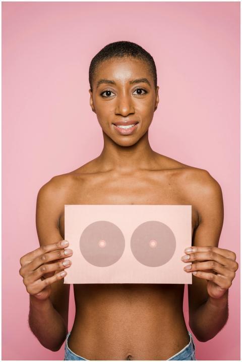 Portrait of woman holding breast chart, supporting