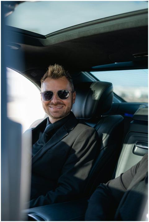 Smiling businessman wearing sunglasses seated in a