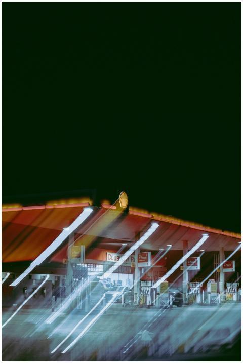Blurred, illuminated gas station at night with abs