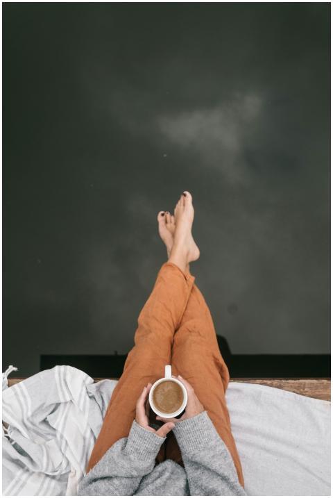 Top view of a person holding coffee, relaxing by w