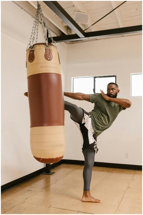 A man practicing martial arts with a high kick on