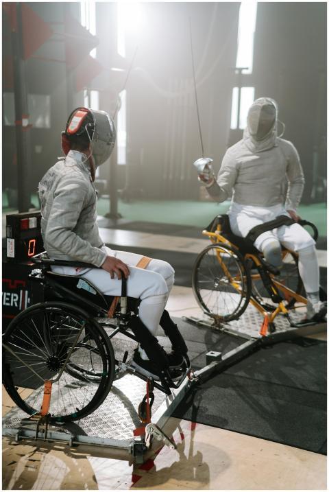 Two athletes engage in an intense wheelchair fenci
