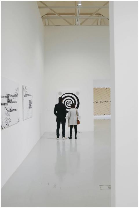 Two visitors admire contemporary artwork in a mini
