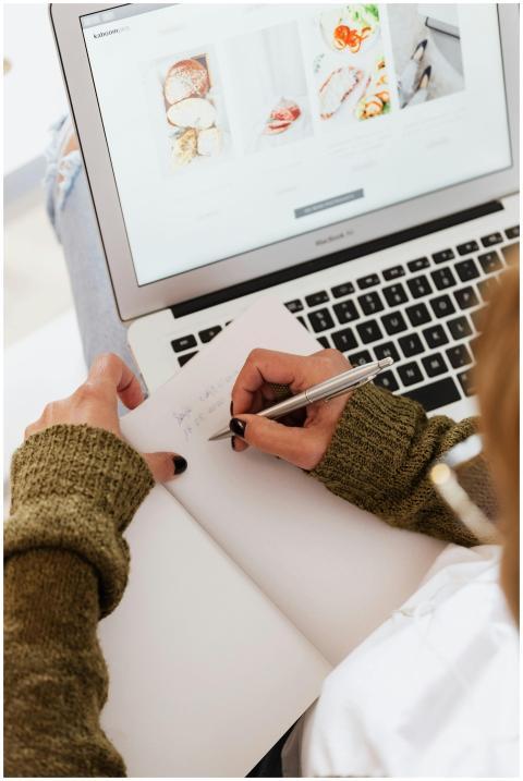 Overhead view of a woman writing in a notebook whi